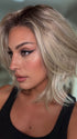 Roxie wearing MIRA by AMORE in SEA SALT BLOND R | A perfect mixture of cool, icy-blond and warm-dark blond. The rich brown root tone enhances the modern appearance.