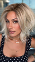 Roxie wearing NEWPORT by BELLETRESS in CRUSHED ALMOND BLONDE R | A soft Neutral Light Blonde with a Light and Medium Blended Root Color.