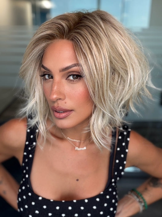 Roxie wearing NEWPORT by BELLETRESS in CRUSHED ALMOND BLONDE R | A soft Neutral Light Blonde with a Light and Medium Blended Root Color.