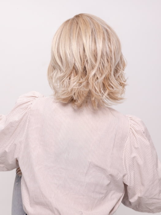 Roxie wearing ALICANTE by BELLETRESS in CRUSHED ALMOND BLONDE R | A soft Neutral Light Blonde with a Light and Medium Blended Root Color.