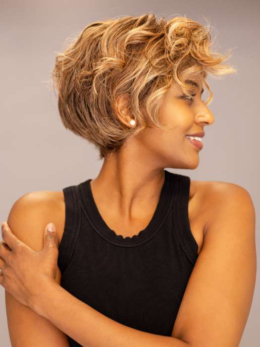 Model is wearing Twisted Pixie by TressAllure in shade EL17/23/R8 | Pale Auburn Beige Blonde Blend, Rooted Medium Brown, Highlighted Light Blonde with face framing highlights