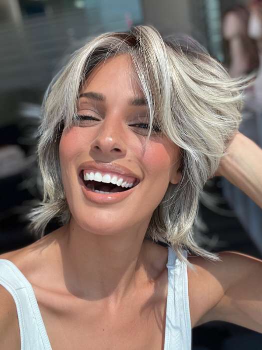 Model is wearing MAIN CHARACTER by RAQUEL WELCH in color RL17/23SS ICED LATTE MACCHIATO | Honey Blonde shaded with Cool Blonde and Dark Roots