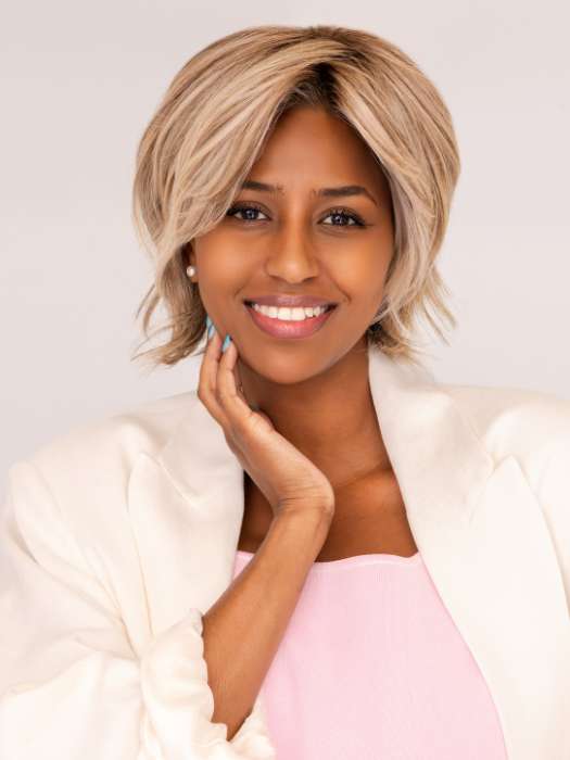 Model is wearing MAIN CHARACTER by RAQUEL WELCH in shade RL17/23SS ICED LATTE MACCHIATO | Honey Blonde shaded with Cool Blonde with Dark Roots