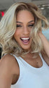 Roxie is wearing AMANDA by ENVY in color CHAMPAGNE SHADOW | Soft Dark Blonde with Platinum Highlights and Chestnut Roots