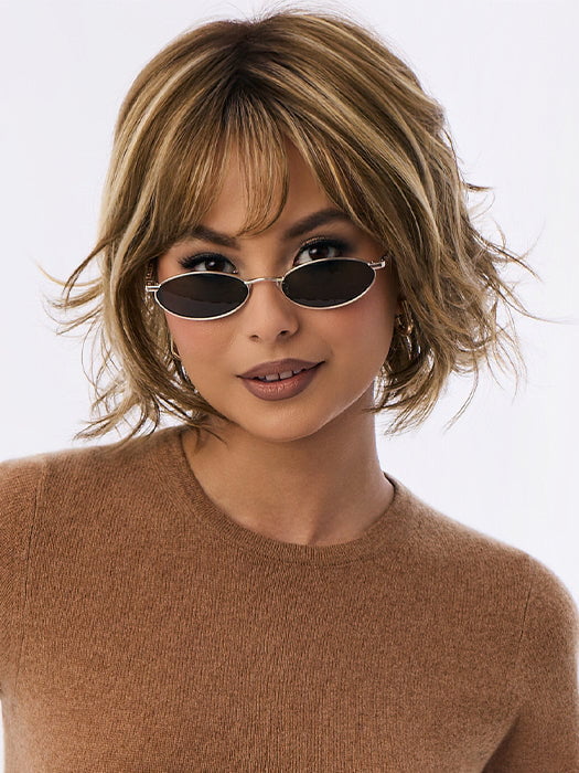 Model is wearing BRANN in color MOCHACCINO-R | MOCHACCINO-R | Rooted Medium Warm Blonde with Chocolate Undertones and Creamy Blonde Highlights