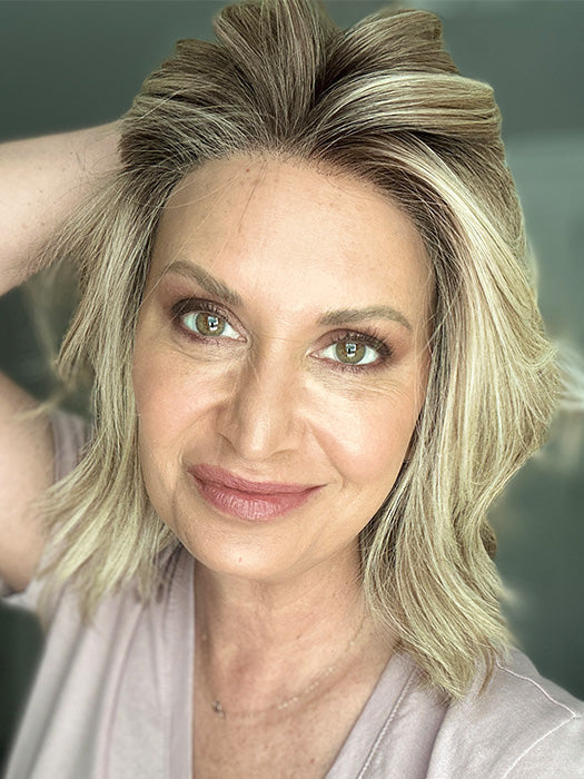 Emily H. @she_sheds_more wearing CYRUS by BELLE TRESS in color BUTTERCAKE BLONDE-R | A neutral-warm blonde blend featuring light brown, ash, and lightest blonde tones with natural-looking darker roots for added depth and realism.
