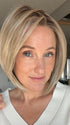 Carly N. @carlynwilson84 is wearing DION by BELLE TRESS in color BUTTERCAKE BLONDE-R | A neutral-warm blonde blend featuring light brown, ash, and lightest blonde tones with natural-looking darker roots for added depth and realism.