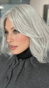 Roxie is wearing HOLLIE PETITE by JON RENAU in shade 56F51 OYSTER | Light Grey with 20% Medium Brown Front, graduating to Grey with 30% Medium Brown Nape 