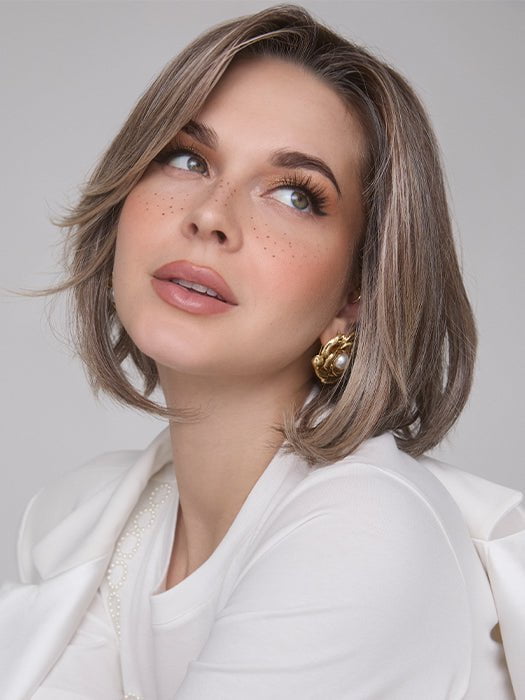 Model is wearing MIRA by AMORE in color TRES CHOCOLATE R | Carefully placed White, Medium, and Dark Chocolate tones completed with a Dark Brown Root. This color is perfect for both Blond and Brown enthusiasts.   