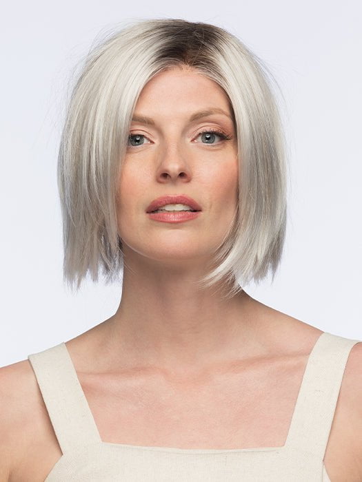 Model is wearing LUMI by Estetica in color SILVERSUN/RT8 | Iced Blonde with Soft Sand and Golden Brown Roots