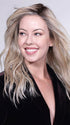 The wavy texture and face-framing layers create a flattering hairstyle