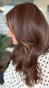 Roxie is wearing MARGO in color GLAZED AUBURN R | Stunning fusion of deep red, medium copper, and dark chocolate root.