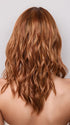 Model is wearing MAUDE by Amore in color RUSTY-SUNRISE-R | Dark brown roots transition into a deep auburn tone with light copper blonde highlights for depth and dimension.