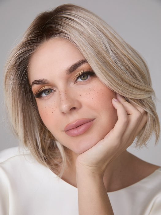 Model is wearing MIRA by AMORE in color SEA SALT BLOND R | A perfect mixture of cool, icy-blond and warm-dark blond. The rich brown root tone enhances the modern appearance.    