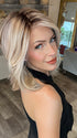 Madeline wearing PARK AVE by BELLE TRESS in color MILKSHAKE BLONDE R | A mixture of Light Sandy Brown, Highlighted with Light Ash Blonde with a Hint of Light Platinum Blonde with a Medium Root Color