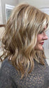 Marcie @wig.obsessed wearing BEACH WAVE MAGIC by TRESSALLURE in color EL12/22/8 | Light Golden Brown Evenly Blended with Face Framing Platinum Blonde Highlights with Medium Brown Roots
