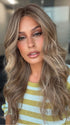 Roxie wearing KATNISS by BELLETRESS in BROWN SUGAR BLONDE-R | A warm, dimensional blend of medium brown and golden blonde highlights with natural-looking darker roots for depth and a sun-kissed finish.