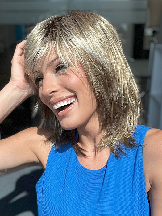 Model is wearing RAINBOW by ELLEN WILLE in color SAND MULTI ROOTED 14.24.12 | Medium Ash Blonde, Lightest Ash Blonde, and Lightest Brown Blend with Dark Shaded Roots