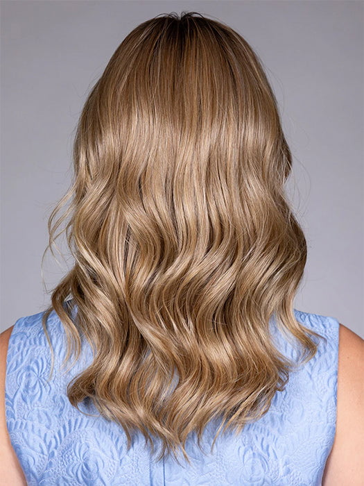 Model is wearing SWIFT in color CARAMEL TOFFEE BLONDE R | Caramel Toffee is a warm, dimensional shade blending medium brown with golden blonde and caramel highlights. Softly rooted for a natural, sun-kissed finish.