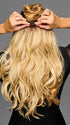 Model is wearing 19IN WAVY INVISIBLE EXTENSION by HAIRDO in color SS14/88H SHADED GOLDEN WHEAT | Dark Blonde Evenly Blended with Pale Blonde Highlights and Dark Roots